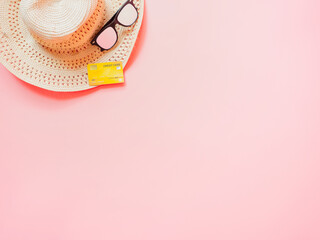 summer accessories concept from credit card and summer collection on pastel red background.