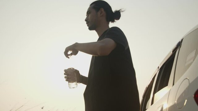 Asian woman drinking water in sun shine with fresh air wave in summer 