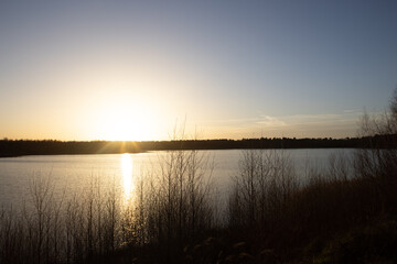 Dramatic and colorful sunset over a forest lake reflected in the water. Blakheide, Beerse, Belgium. High quality photo