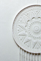 Handmade dream catcher with feathers threads and beads rope hanging on white background