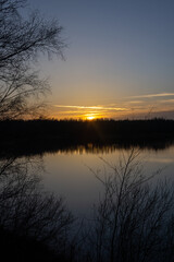 Dramatic and colorful sunset over a forest lake reflected in the water. Blakheide, Beerse, Belgium. High quality photo
