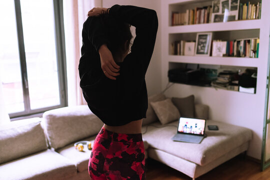 Woman stretching, following online exercise class