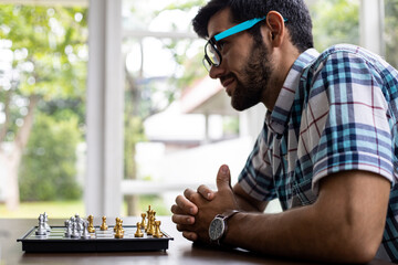 Man developing chess strategy, playing board game.
