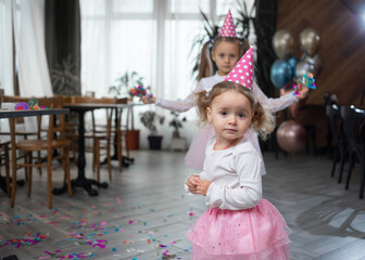 portrait of a little girl, she is wearing a festive cap. Birthday celebration concept.