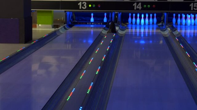 Colorful bowling alley. Bowling game. A bowling ball traveling down the lane and knocks down pins