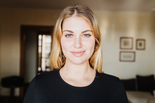 Head and shoulders portrait of young woman at home