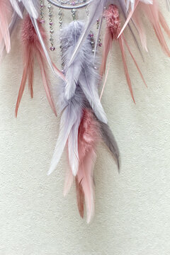 Handmade dream catcher with feathers threads and beads rope hanging on white background © dashtik