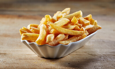 Homemade fried potatoes in plate on wooden table