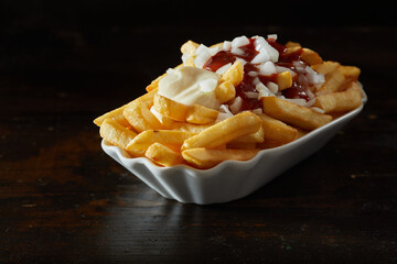 Portion of French fries with mayo and ketchup in plate