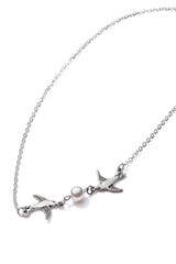 Cropped close-up of silver necklace with two golden swallows and pearl bead. The stylish jewelry is isolated on the white background. 