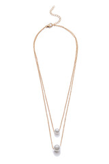 Subject shot of elegant golden necklace made as two chains with pearl beads. The adjustable necklace with lobster clasp and extension chain is isolated on the white background.