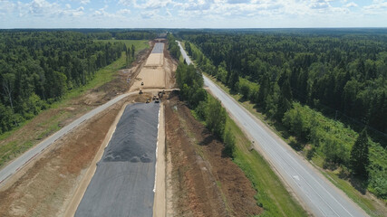 Fototapeta na wymiar Construction of toll roads in rural areas. Aerial view construction of a new highway next to the old highway.