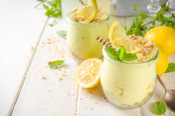 No baked homemade lemon cheesecake with mint in small vintage jars