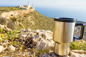 Naklejka premium Thermal mug, thermos on nature. Travel outdoor picnic.