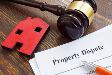 Property dispute documents, small home and gavel.