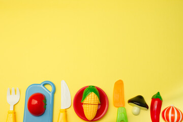 Creative composition of toy fruits and vegetables on a pastel yellow background. Minimum summer concept. Surrealism.