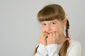 kid child beautiful little girl bites her fingernails concept photo
