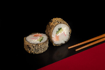 Sushi Sets Uramaki, California, Philadelphia, on a white plate. Festive new year concept. Against a dark reflective background.