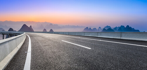 Empty asphalt road and beautiful mountains at sunrise in Guilin,China.