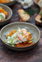 ovo pochê em uma placa com brinde e abóbora cozido e pasta de grão de bico. 