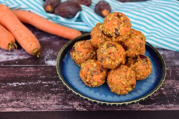 Carrot oat date energy balls. Gluten free and vegan food. Wooden background