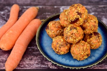 Carrot oat date energy balls. Gluten free and vegan food. Wooden background