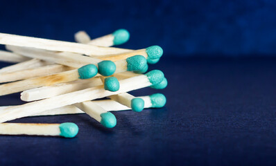 A pile of matches on a blue background. Green sulfur on matches.