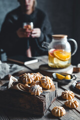 Woman is sitting with Hot tea with fresh grapefruit on wooden tablet. Healthy drink, Eco, vegan.