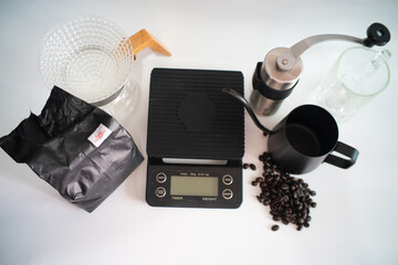 Hot coffee drip on white background with hand mechanic grind coffee and scale