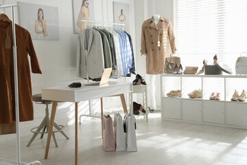 Collection of stylish women's clothes, shoes and accessories in modern boutique - obrazy, fototapety, plakaty