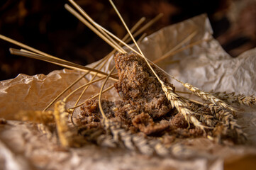 Rye bread with rye spikelets on unfolded parchment paper.