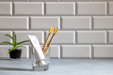 Bamboo toothbrushes and toothpaste in glass. Zero waste concept. Eco-friendly accessories
