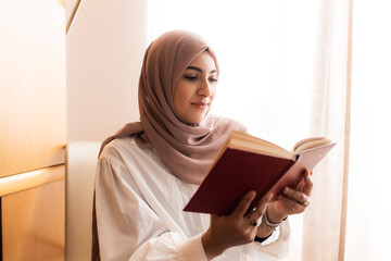 Young muslim woman reading book