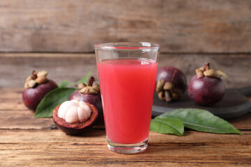 Delicious fresh mangosteen juice in glass on wooden table