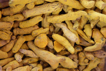 A lot dried turmeric curcuma roots spices ingredient for pilaf food cooking, natural background texture