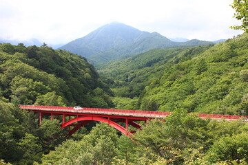 山と山の間に谷に架けられた赤い橋（山梨県野辺山高原にて）