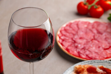 Meat slicing and wine on gray background