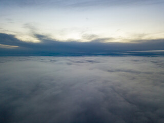 Fototapeta na wymiar High flight above the clouds at sunset. Aerial view.