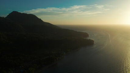Sunset on tropical island with coast and sea, aerial view. Seascape: Ocean and sky.Philippines, Camiguin.