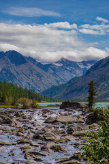 Fototapeta na wymiar View of the snowy peaks from the noises of the second multinsky lake in the mountains of Altai