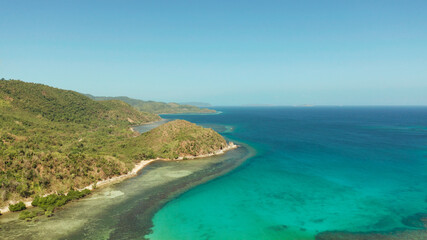 Fototapeta premium Aerial view coastline of a tropical island with coral reef and blue lagoon. Busuanga, Palawan, Philippines. tropical landscape