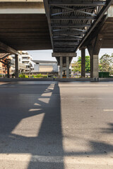 construction pier under highway while vehicle movement on road with shadow lighting on under cross bridge