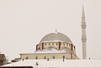 Fototapeta na wymiar Erzurum, Turkey 03. 01 2021 Snow and Ice on the Roof of a mosque (Turkish: Molla Sıddık Camii) Travel Turkey. Snowfall. Cold weather -50 degrees Celsius, winter. Freeze, freezing. Roof ice dams