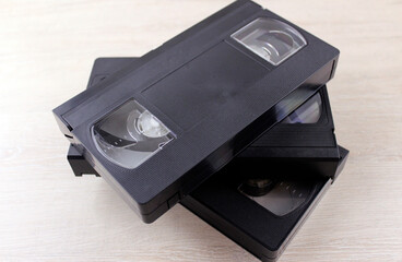 Stack of old plastic videotapes on wooden background
