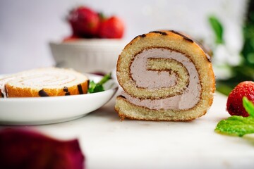 Strawberry Swiss roll or Roulade with cream filling and chocolate drizzle, selective focus