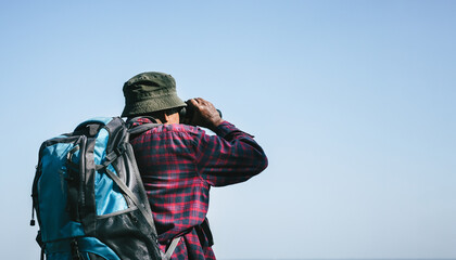 elderly man hiker using binoculars outdoors.