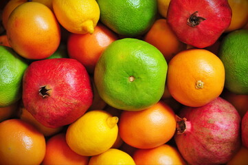 Lemons, limes, oranges, tangerines, grapefruits and pomegranates background