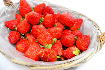Bright red juicy strawberries in a basket in the snow in winter, a gift for March 8