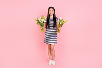 Obraz na płótnie Canvas Full length body size photo of happy woman keeping two tulips bouquets on 8 march isolated on pastel pink color background