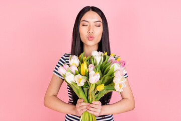 Photo portrait of brunette girl keeping flowers bouquet with pouted lips isolated on pastel pink color background